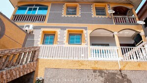 A multi-story building with balconies, a covered porch, and a staircase. - Odza, modern apartment, 3 bedrooms, private parking (Yaoundé)