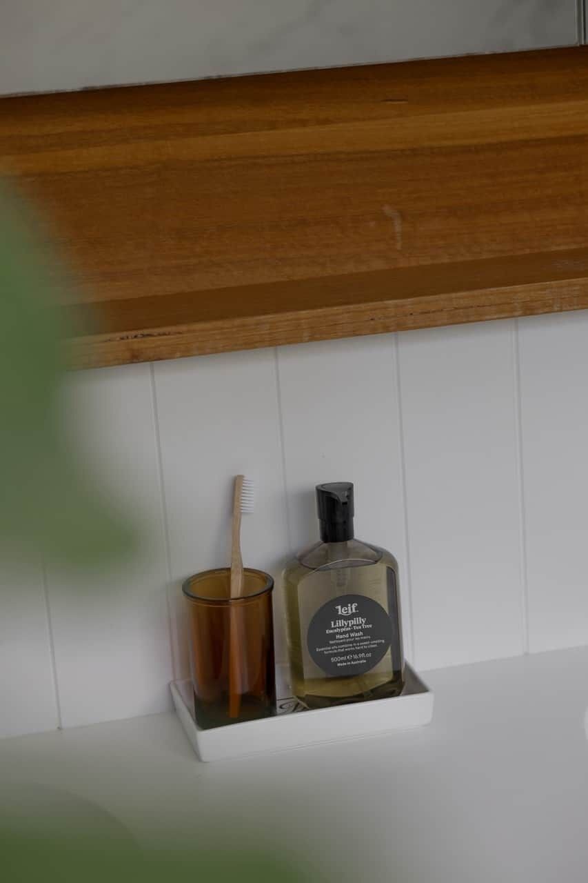 Ein Badezimmerschrank mit einer Zahnbürste und einer Handdesinfektionsmittel-Flasche.