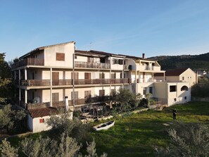 A multi-story building with balconies and a small boat in the foreground.