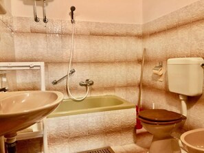 A bathroom with a sink, toilet, and bathtub.