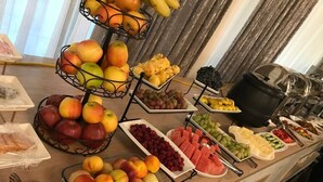 A buffet with various fruits and vegetables, including apples, pears, grapes, and watermelon. - Continental Hotel (Samarkand)