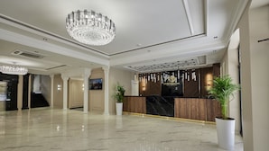 A spacious lobby with a marble floor, a reception desk, and a chandelier. - Continental Hotel (Samarkand)