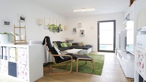 Un soggiorno moderno con un divano, due poltrone, un tavolino e un tappeto verde.