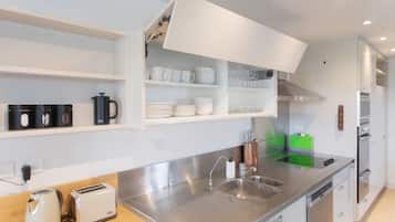 A modern kitchen with stainless steel appliances, a built-in oven, and a dishwasher.