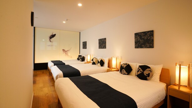 Habitación de hotel con dos camas, lámparas de noche y obras de arte en las paredes.
