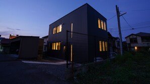 Una casa moderna de dos pisos con patio cercado y garaje.