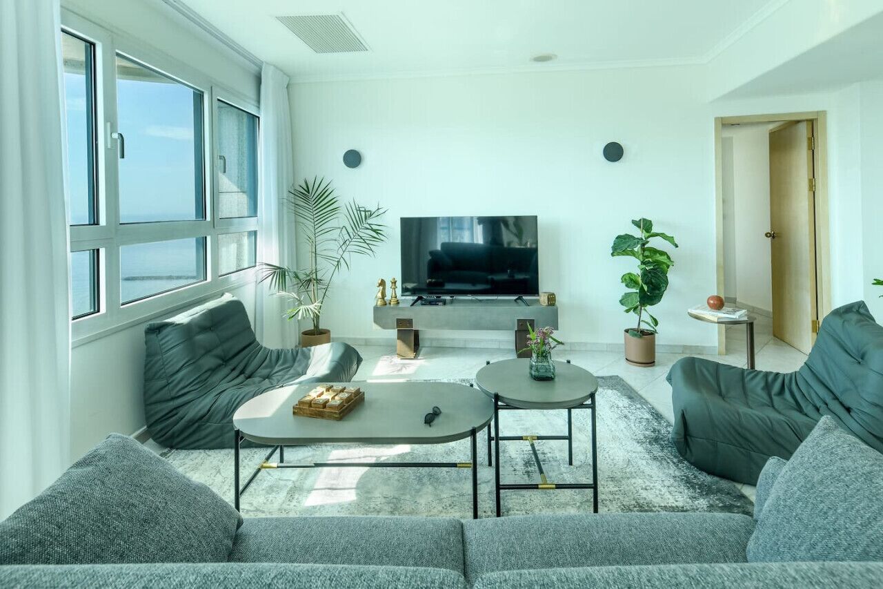 Uma sala de estar moderna com um sofá, uma mesa de centro e uma televisão.