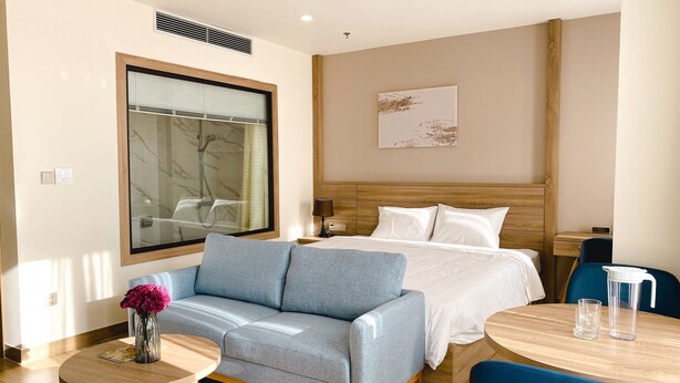 Une chambre d’hôtel avec un lit, un canapé, une petite table et une chaise.