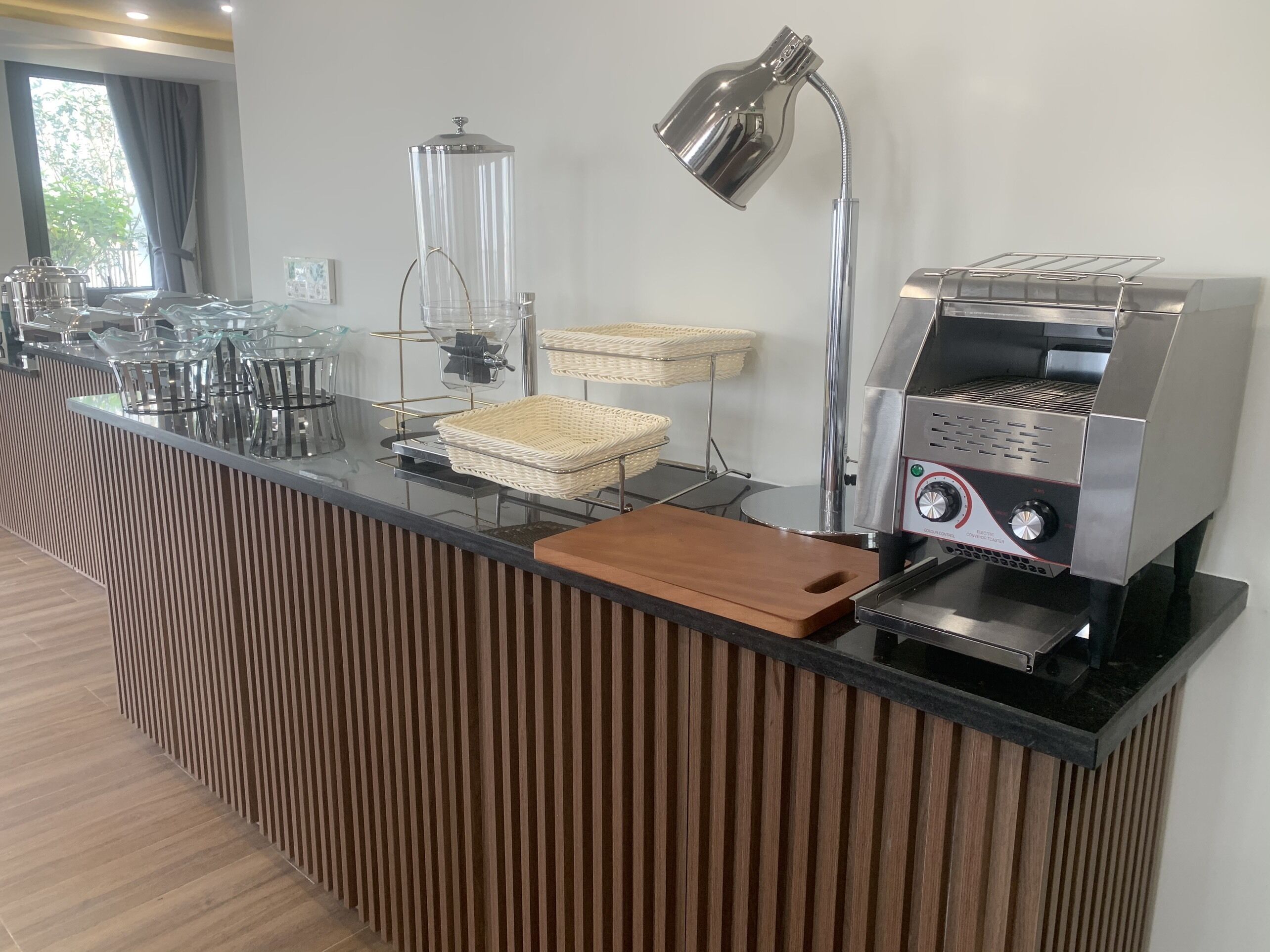 Un área de cocina moderna con cafetera, hervidor y lámpara.