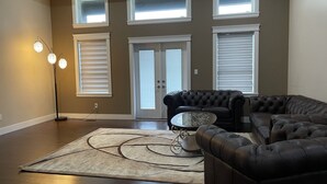 A spacious living room with a sectional sofa, a coffee table, and a floor lamp. - Gorgeous house on the top of the mountain in Chilliwack (Chilliwack)