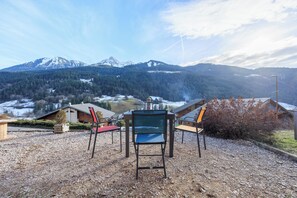 Aussicht auf eine Berglandschaft mit Chalet und Sitzbereich.