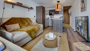 A modern apartment with a living area, kitchenette, and a dining space.