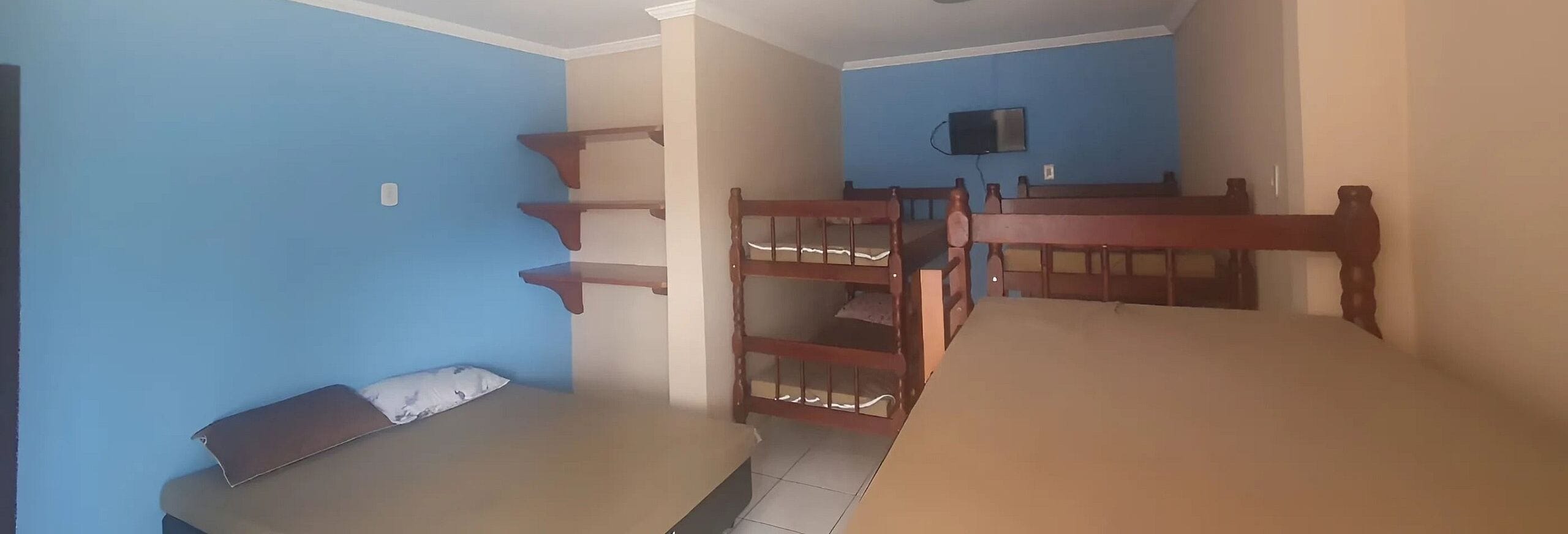 A room with bunk beds, a television, and a small table.