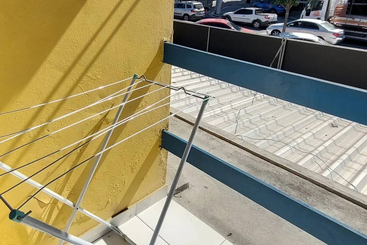 Un balcon doté d’une rambarde en métal donnant sur une rue où sont garées des voitures, et sur laquelle on aperçoit un camion Nissan Frontier.