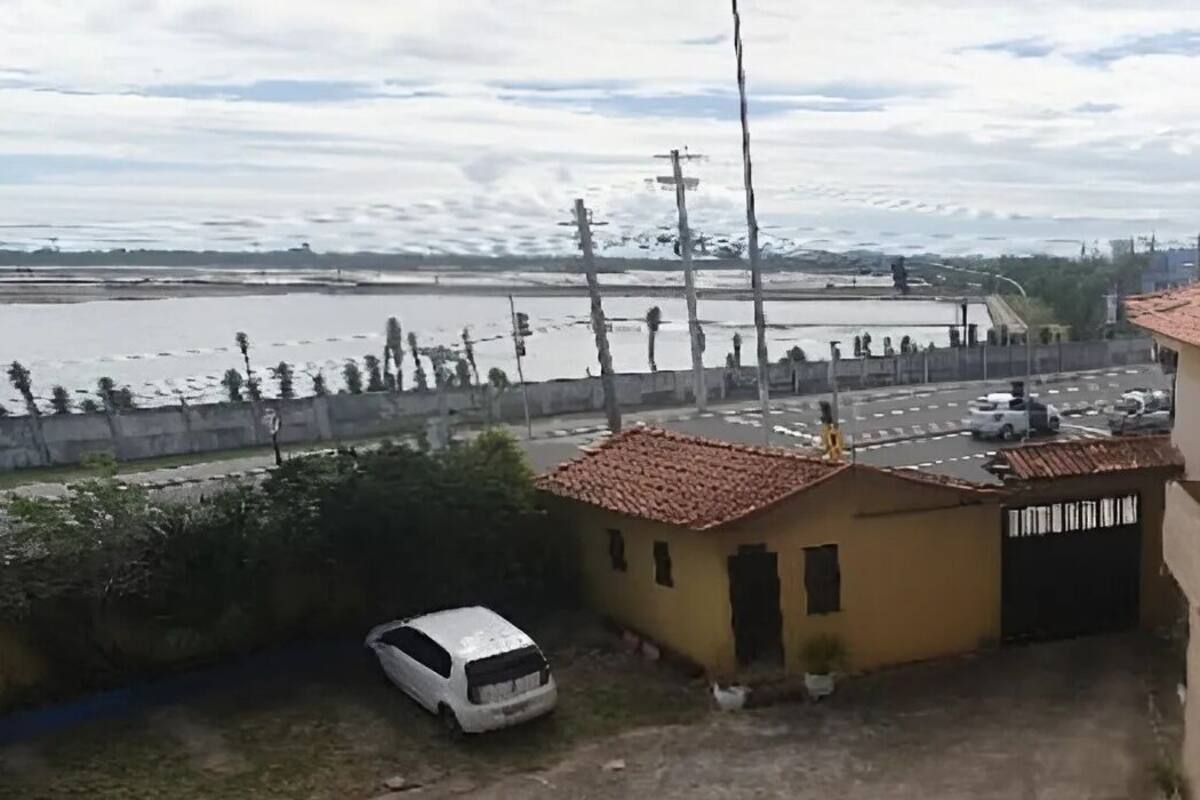 Un bâtiment avec un toit recouvert de tuiles rouges, une petite construction adjacente et un fourgon blanc garé devant.