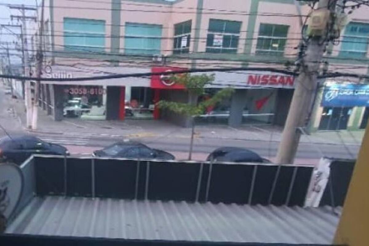 Une vue d’une rue avec des voitures et une concession Nissan.