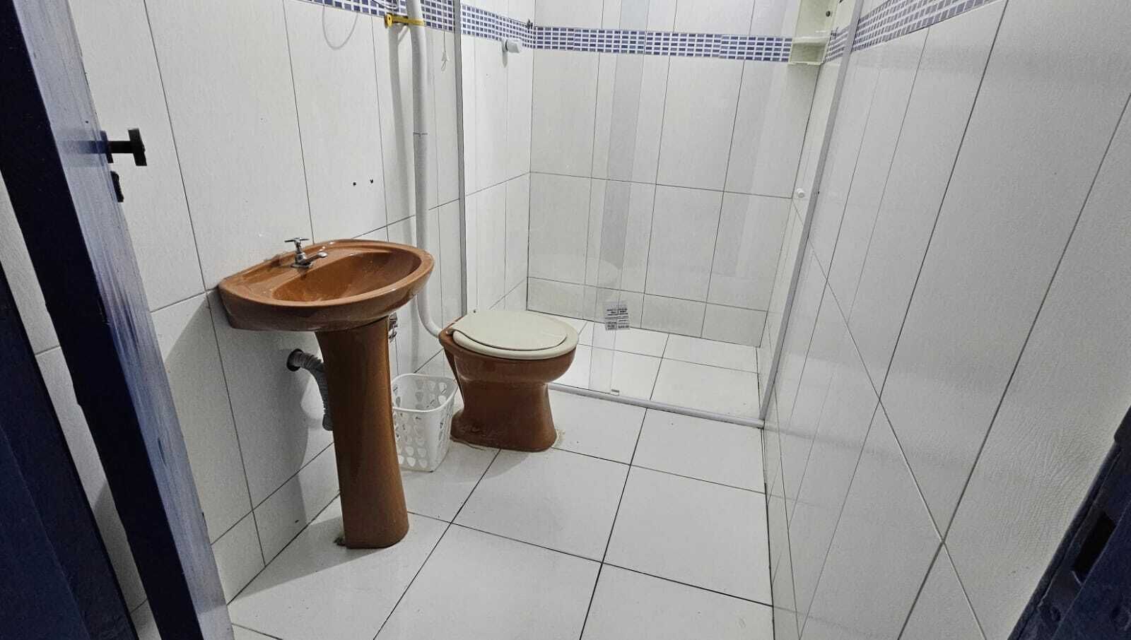 A small bathroom with a sink, toilet, and shower.