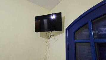 A flat-screen TV mounted on a wall with visible electrical cords.