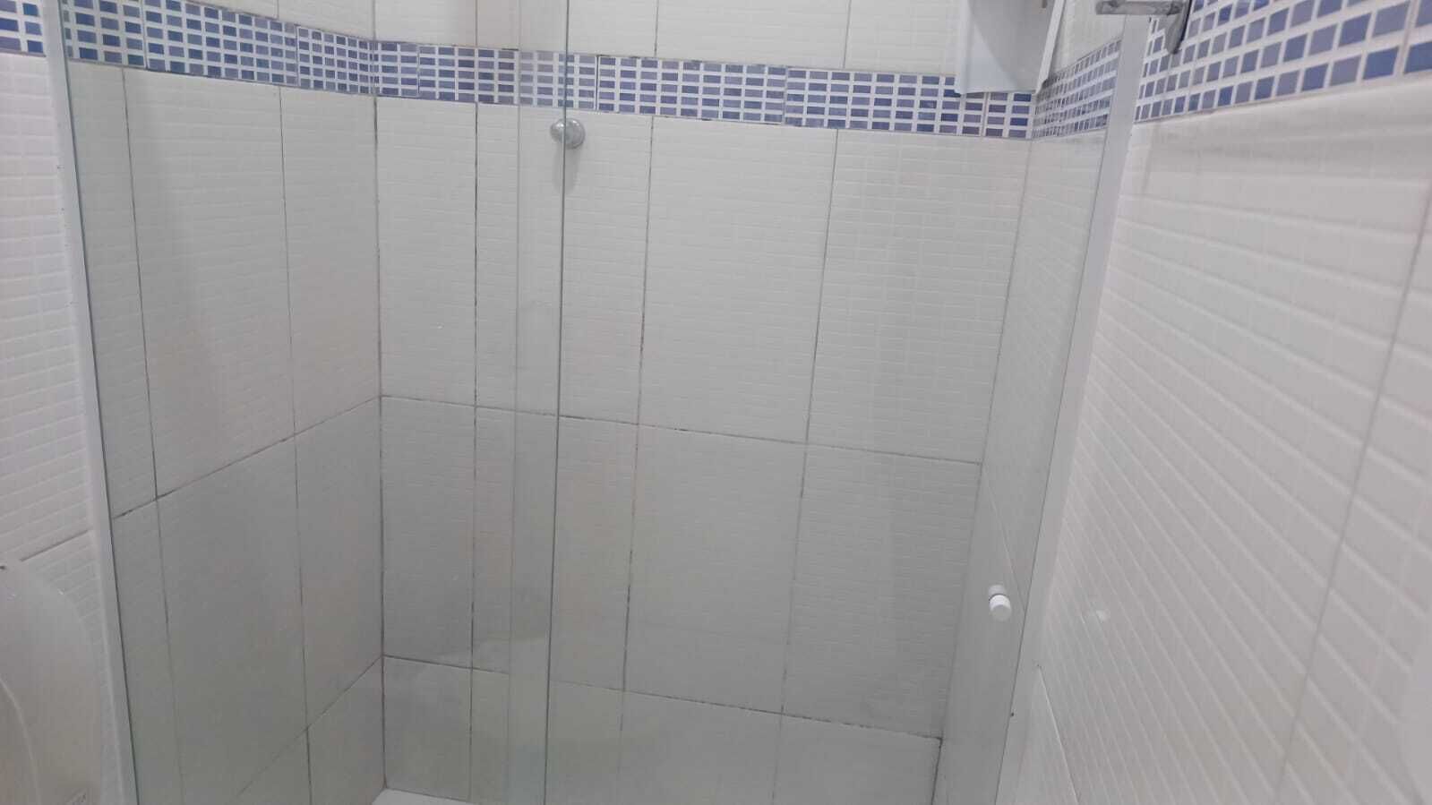 A tiled shower enclosure with a door and a handle.