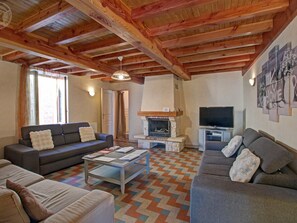 A cozy living room with a fireplace, sofas, a coffee table, and a television. - Charming Cottages with Fireplace and Pets Welcome, 11 People (Vézelin-sur-Loire)