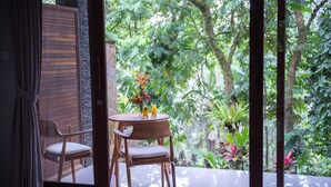 A wooden-framed window with a view of lush greenery. - Angsoka Bungalow (Ubud)