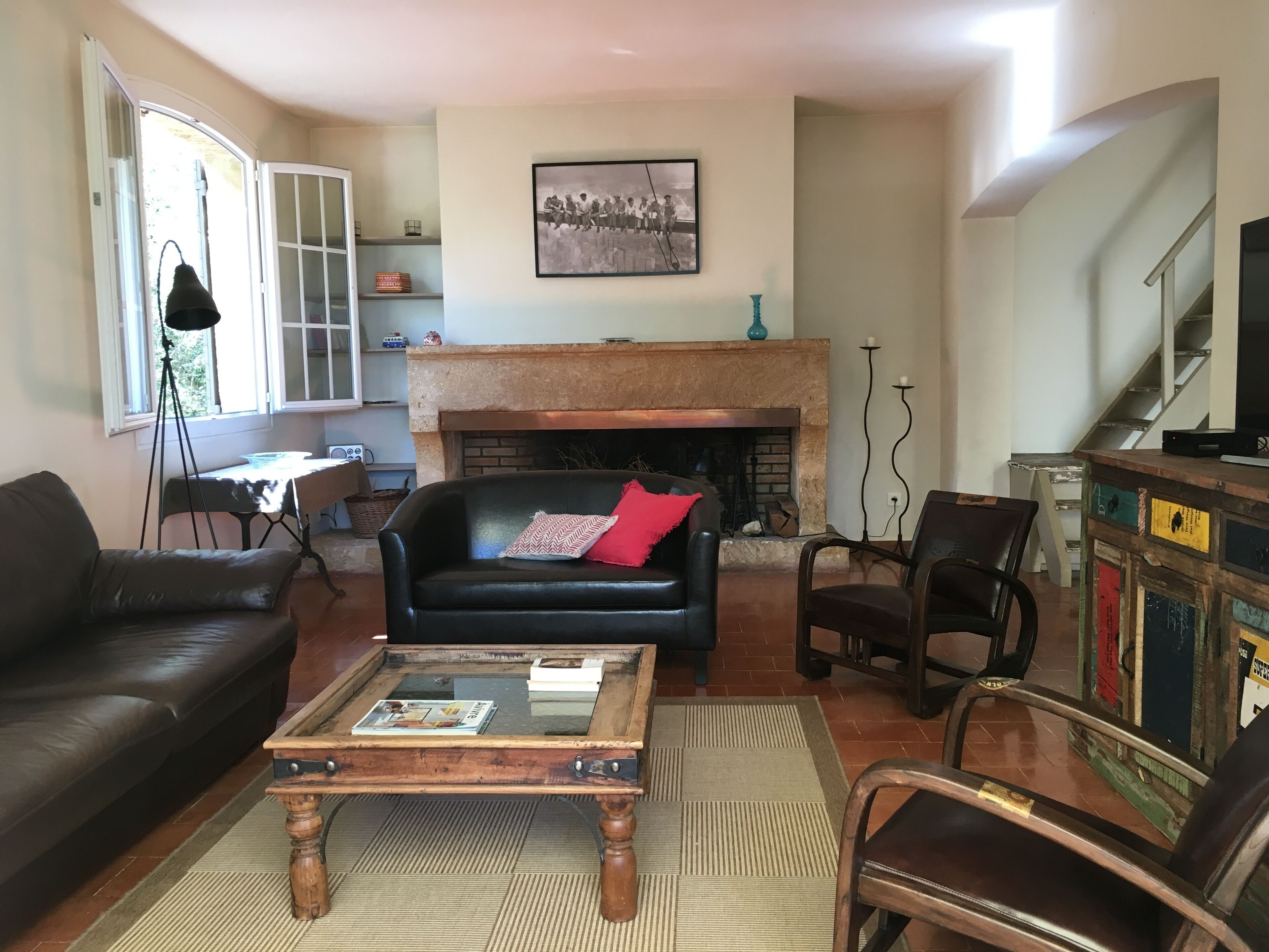 A living room with a fireplace, a sofa, a coffee table, and a bookshelf.