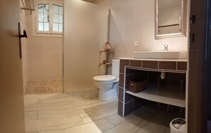 Een badkamer met toilet, wastafel en douche.
