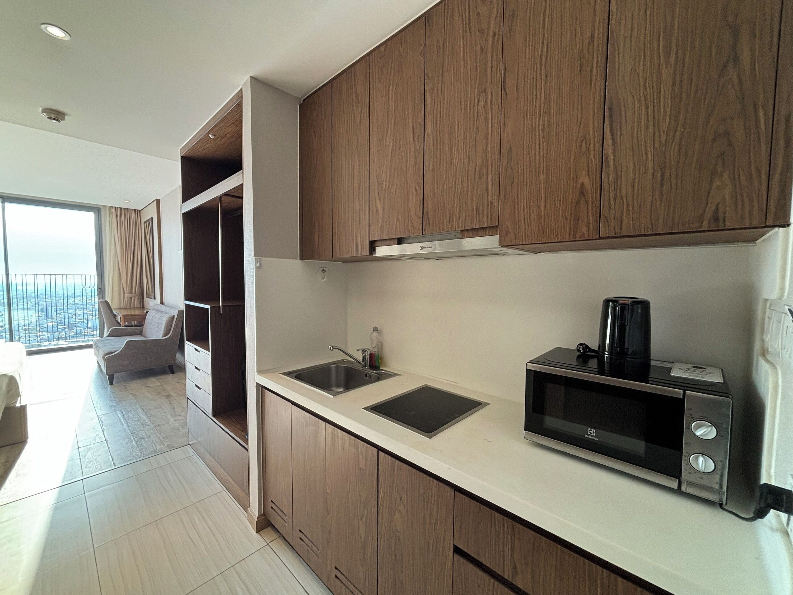 A modern kitchen with wooden cabinets, a built-in microwave, and a sink.