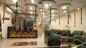 A reception area with a 'PUSH' sign, a decorative wall, and several potted plants. - Hotel City Heritage Haridwar (Haridwar)