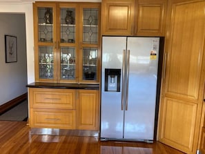 Kitchen area with cabinetry, refrigerator, and water dispenser.