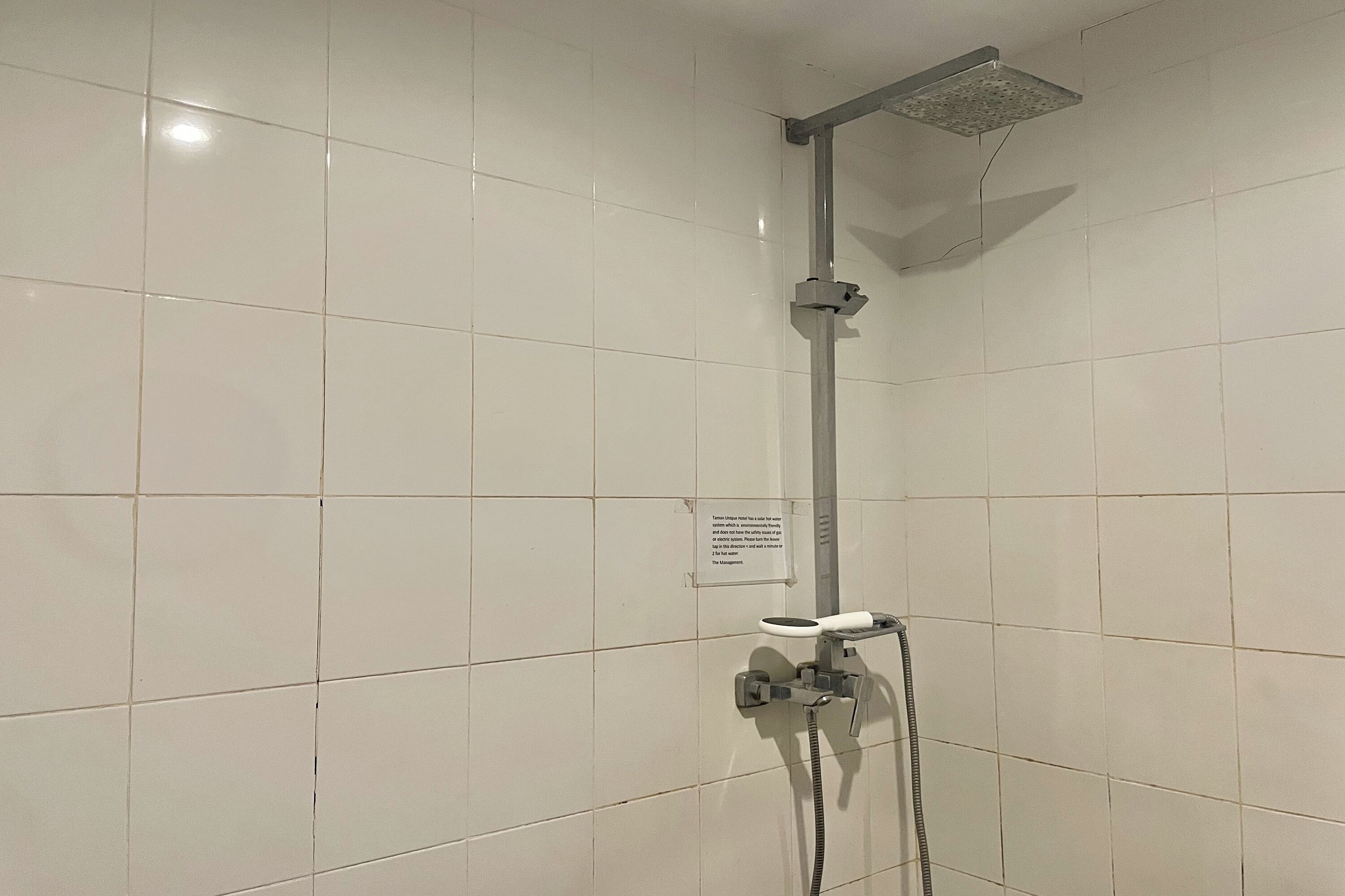 Ducha con cabezal de ducha de mano y grifo empotrado.