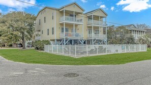 A multi-story building with balconies and a fenced courtyard.