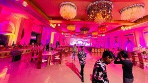 A spacious hall with chandeliers, tables, and chairs arranged for an event. - Vrinda Resort by Dcrest  (Mathura)