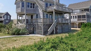 A two-story house with a balcony and a staircase leading to the upper floor. - D124- Classic Duck Oceanfront - 4 Brs Outstanding Ocean Views & Comm. Pool (Duck)