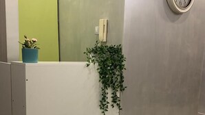A reception area with a clock, a potted plant, and a phone on the wall. - Napoleone Luxury Home (Rome)