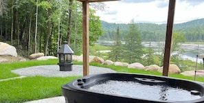 A hot tub with a view of a forest and a river. - Lakeview Luxury Cottage w/ Private Spa (Sainte-Adèle)