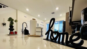 Eine moderne Küche mit einem großen Schild mit dem Aufschrift 'home', einem Spülbecken, einer Pflanze und einer Kaffeemaschine.