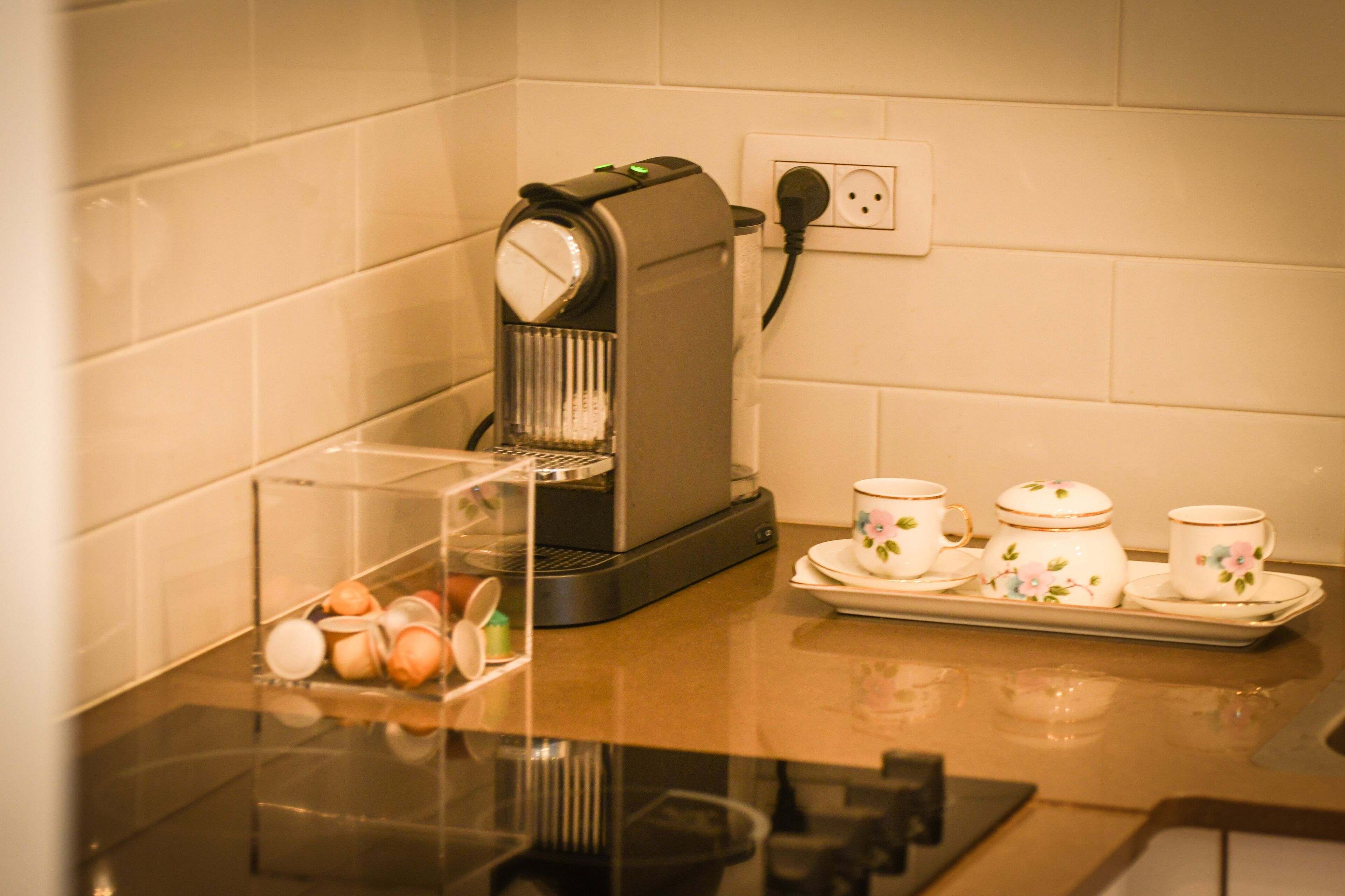 Een koffiezetapparaat op een keukentafel met een schaal thebekers en een doorzichtige container met eieren.