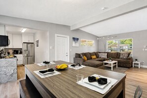 A modern living space with a kitchen, dining area, and seating area.