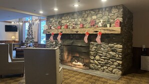 A cozy living room with a stone fireplace, a Christmas tree, and holiday decorations. - Ski-In/Ski-Out at Jiminy Peak  in the Country Inn (Hancock)