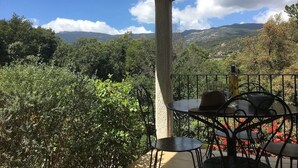 Un espacio de estar al aire libre con techo y vistas a un paisaje montañoso.