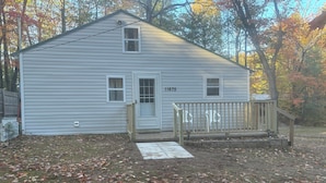 A single-story house with a front porch, a mailbox, and a number "11675" on the door. - Small quaint cabin with outside hot tub! sleeps 6! (Kalkaska)