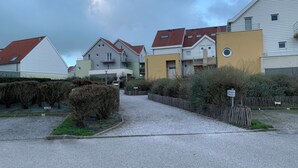 A residential area with houses, a gravel path, and a wooden fence. - PANORAMIC sea, dunes and golf view apartment (Wimereux)