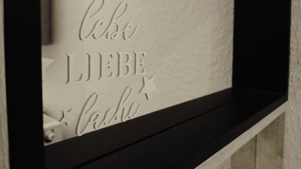 Een muur met een decoratief bordje waarop in een bijzondere letter 'Ich liebe dich' staat.