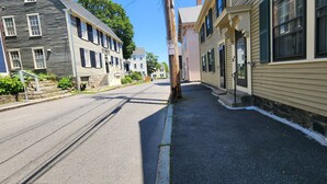 A quiet street lined with historic buildings, a clear sky, and a 'No Parking' sign. - Sailor’s Retreat – Old Town Stay Near Salem & Harbor (Marblehead)