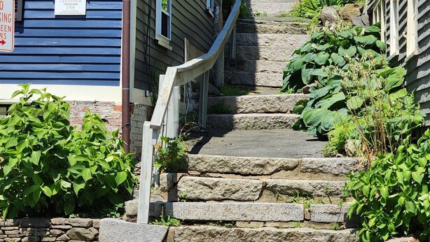 A residential street with a blue house, stone steps, and a sign commemorating John Lefavour. - Sailor’s Retreat – Old Town Stay Near Salem & Harbor (Marblehead)