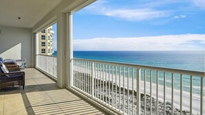 Ein Balkon mit Blick auf den Ozean und ein Gebäude gegenüber.
