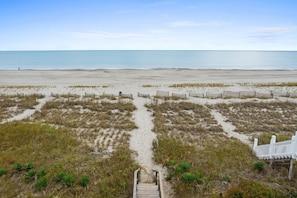 A beach with a wooden pathway leading to a white fence, sandy dunes, and a clear view of the ocean. - Sea You Soon / 207 Brunswick Ave West 4 Bedroom Home by RedAwning (Supply)
