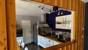 Una cocina moderna con armarios blancos, una encimera de madera y un horno empotrado.