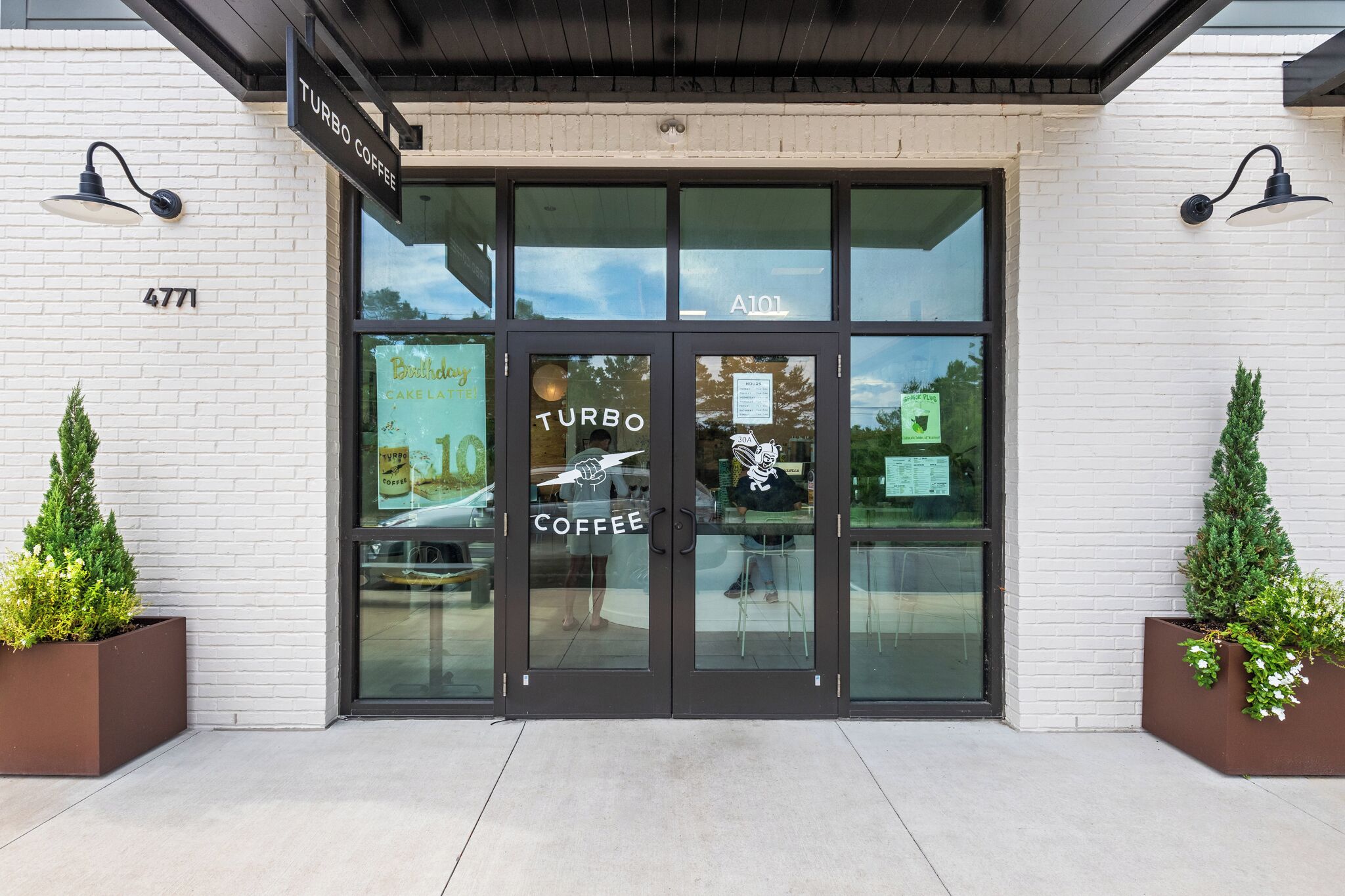 A storefront with a sign reading "Turbo Coffee" and a large glass door.
